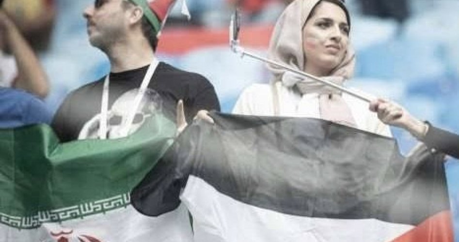 مشجعان يحملان علمي فلسطين وإيران بمونديال قطر