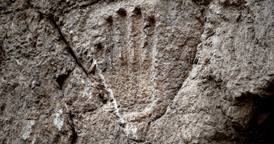 نقش لكف يد على جدار حجري صخري في خندق بالقدس